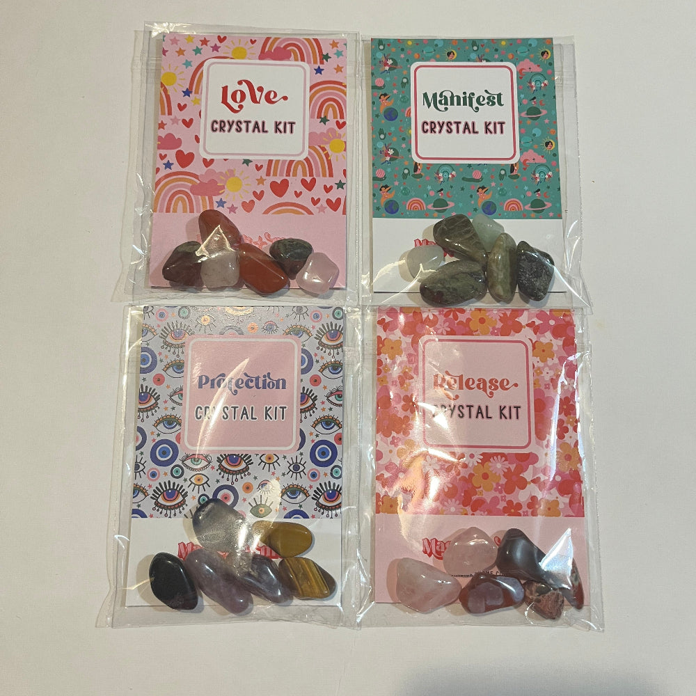 Four crystal kits with colorful packaging on a white surface.